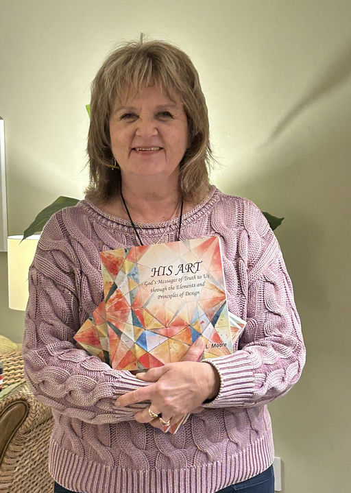Paula Moore holding His Art